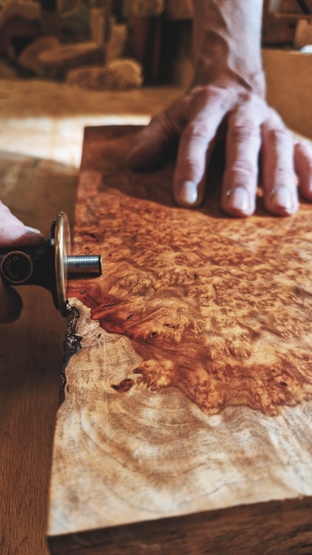 Handwerkerhände zeichnen ein Maß an einem Edelholz-Werkstück aus Amboina Maser an